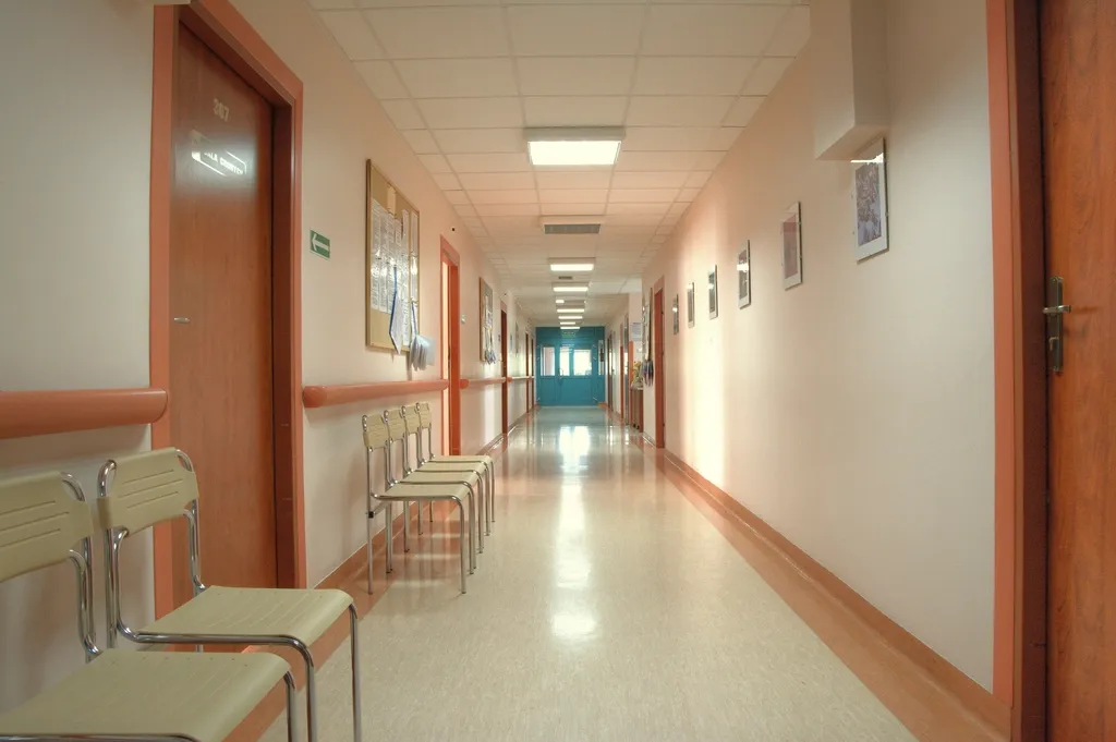 Bright hospital corridor with doors along one side