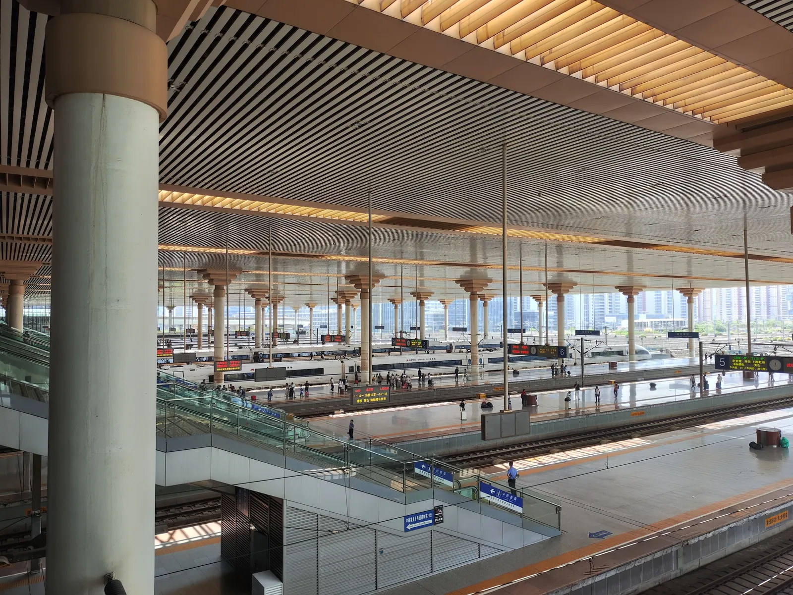 Wide railway station hall with platforms under a steel roof